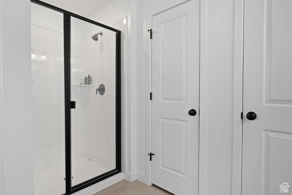 Bathroom featuring a shower stall and tile patterned floors