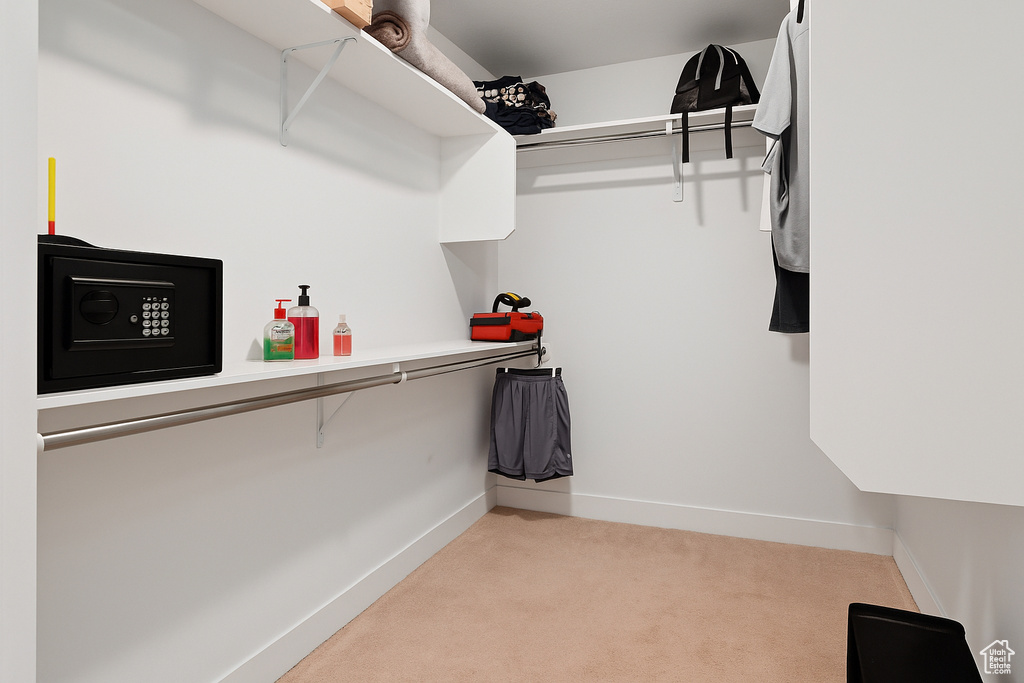 Walk in closet featuring light colored carpet