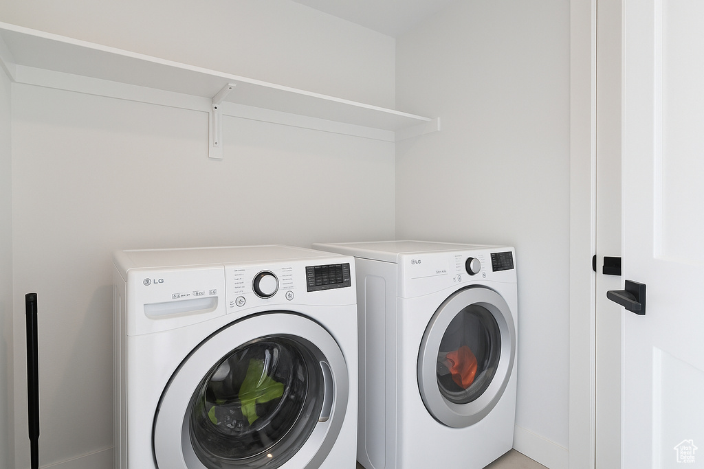 Washroom featuring washing machine and dryer and baseboards