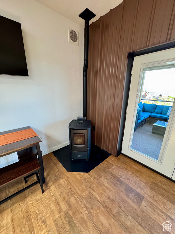 Living area featuring a wood stove, wood finished floors, and baseboards