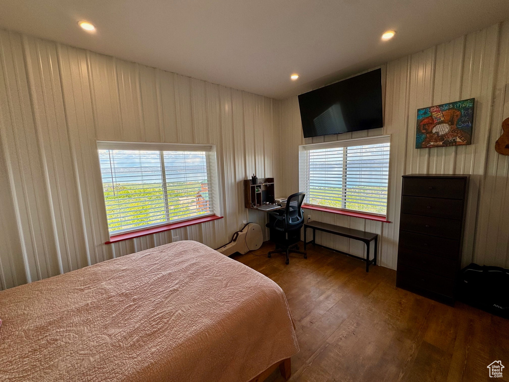 Bedroom with wood finished floors, radiator, wood walls, and recessed lighting