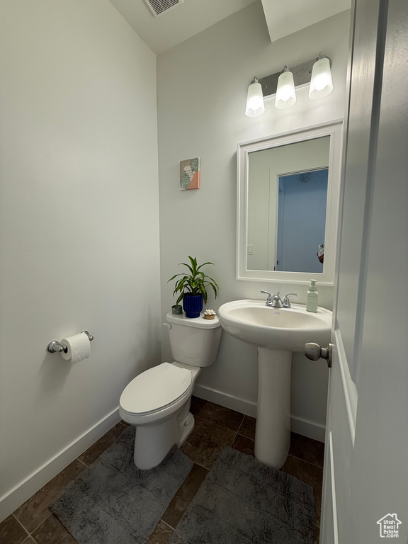 Half bath featuring toilet and baseboards