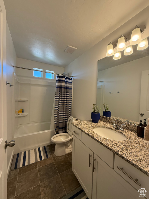 Full bath with vanity, toilet, and shower / bath combo with shower curtain