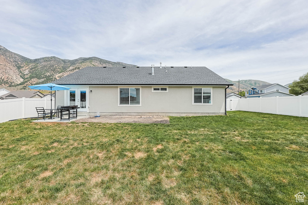 Back of property with stucco siding, a patio area, french doors, and a mountain view