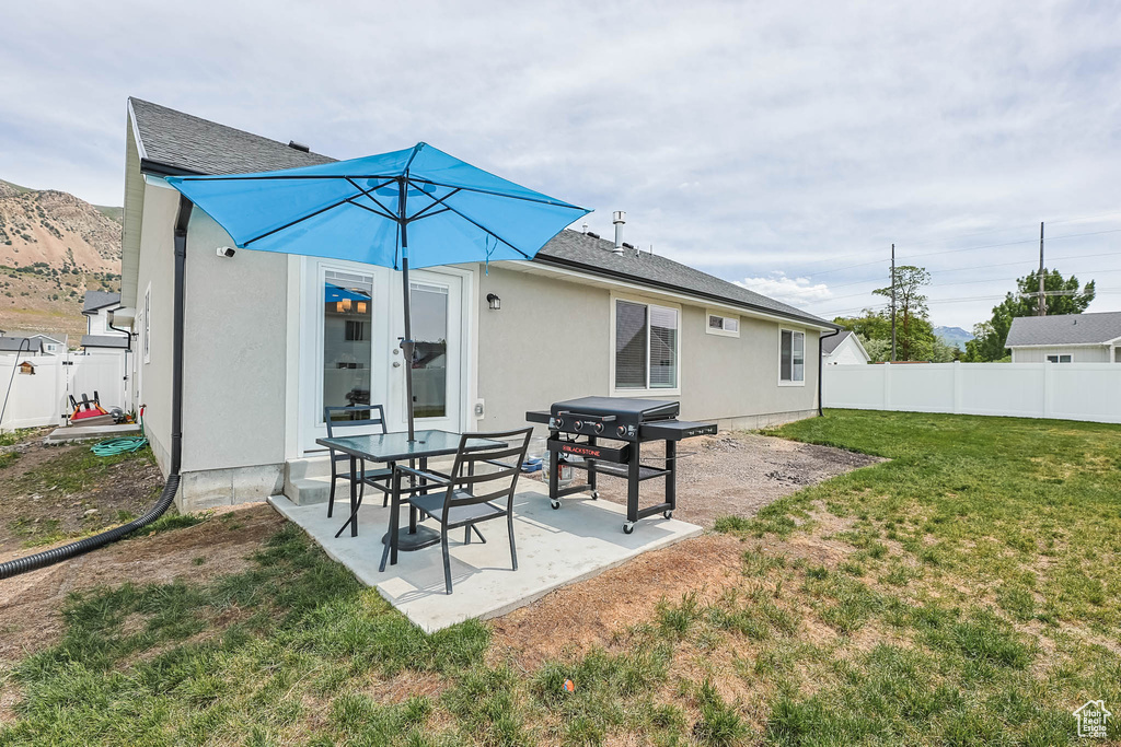 Back of house featuring a patio area, stucco siding, and roof with shingles