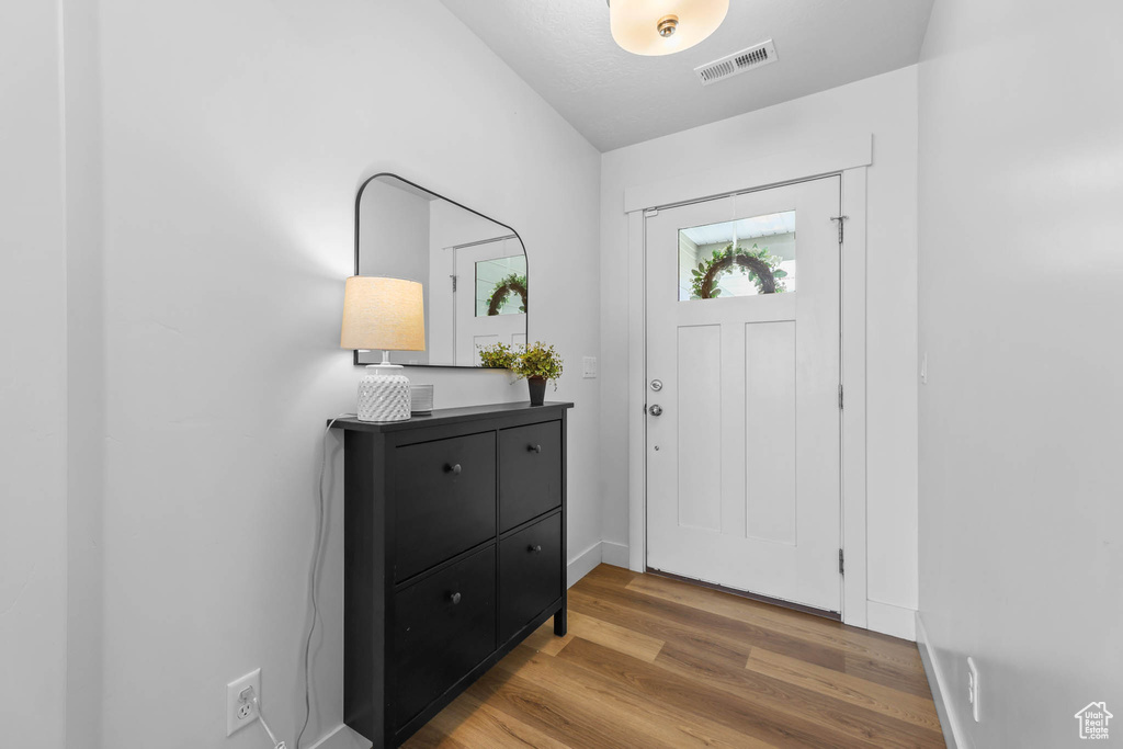 Entryway with wood finished floors and baseboards