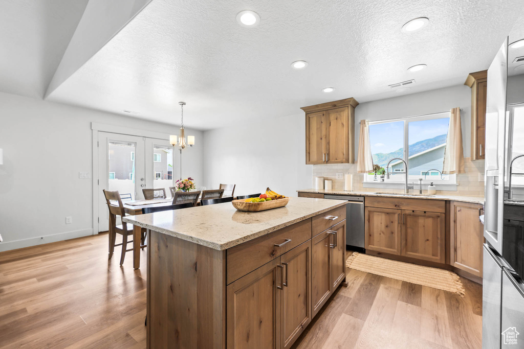 Kitchen with a sink, stainless steel appliances, backsplash, light wood-style flooring, and recessed lighting