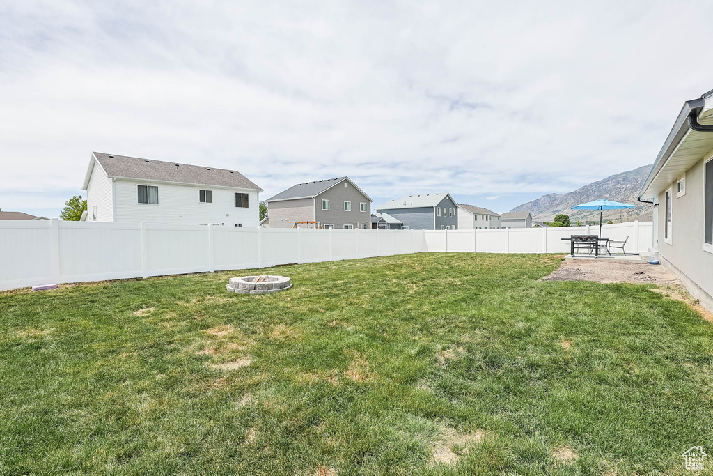 View of yard with a patio, an outdoor fire pit, and a residential view