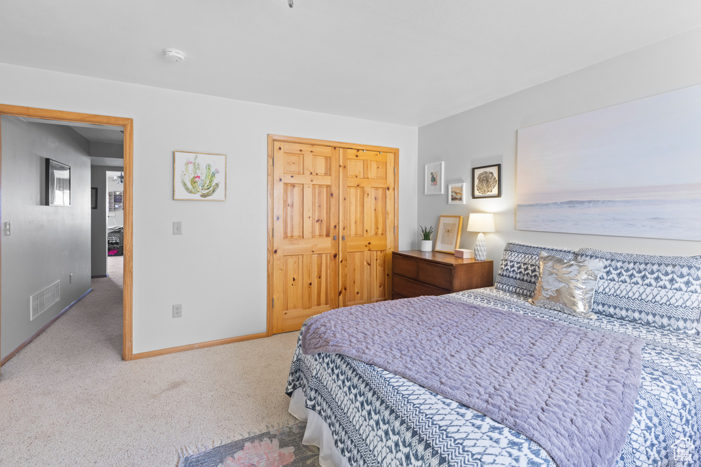 Carpeted bedroom with baseboards and a closet
