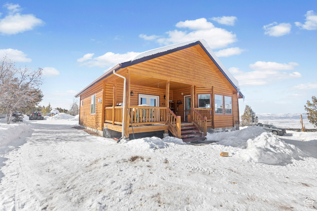 Rustic home with a porch and faux log siding
