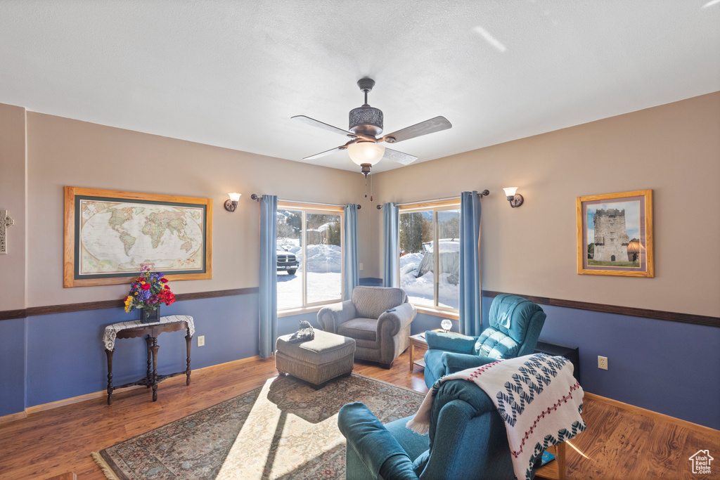 Living room featuring a ceiling fan, wood finished floors, and baseboards