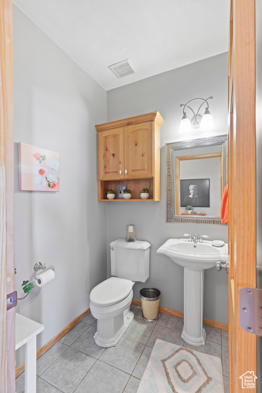 Bathroom featuring baseboards, toilet, tile patterned flooring, and vaulted ceiling