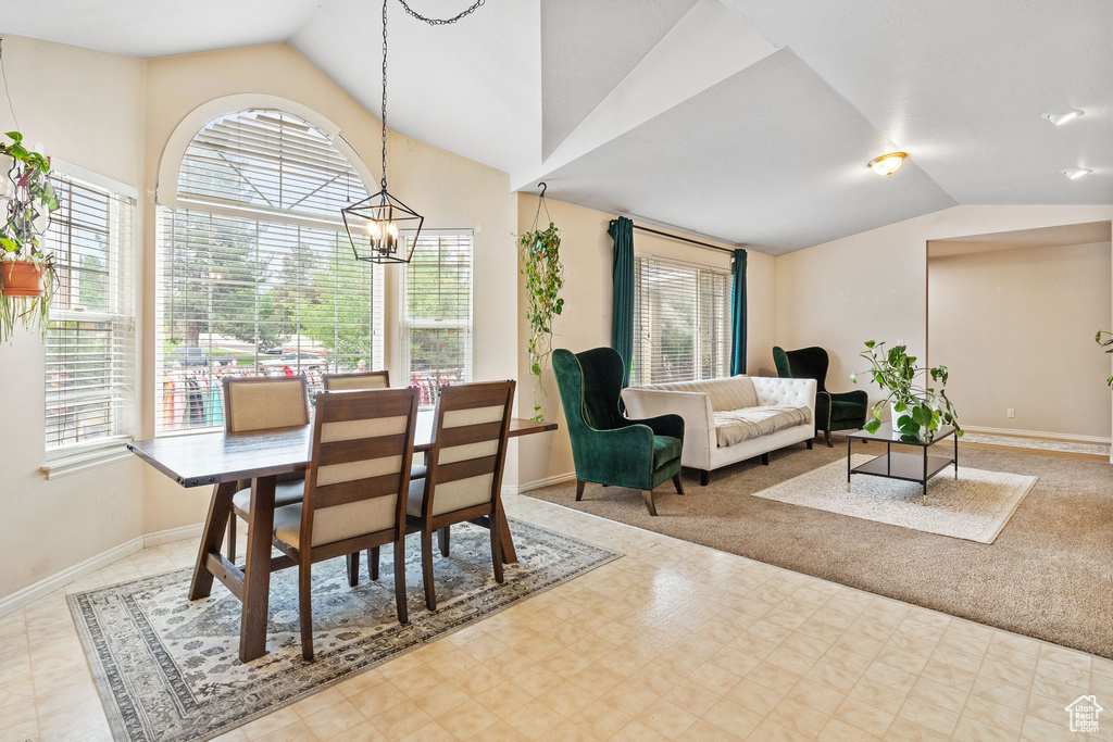 Dining space featuring vaulted ceiling, plenty of natural light, baseboards, and tile patterned floors