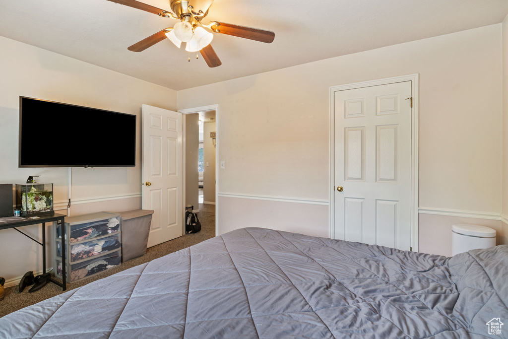 Carpeted bedroom featuring a ceiling fan