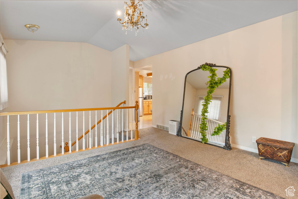 Corridor featuring an upstairs landing, carpet, vaulted ceiling, baseboards, and a chandelier