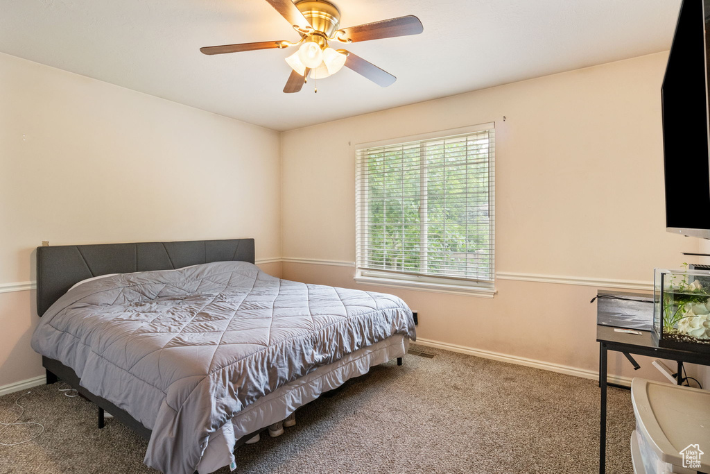 Bedroom featuring carpet flooring, baseboards, and a ceiling fan