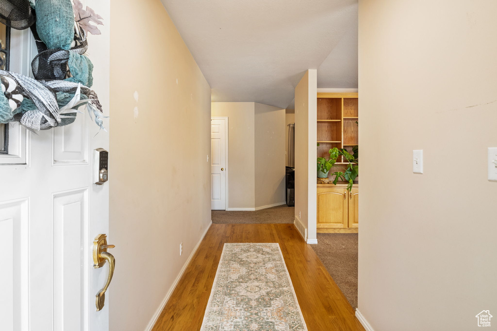 Corridor with wood finished floors and baseboards