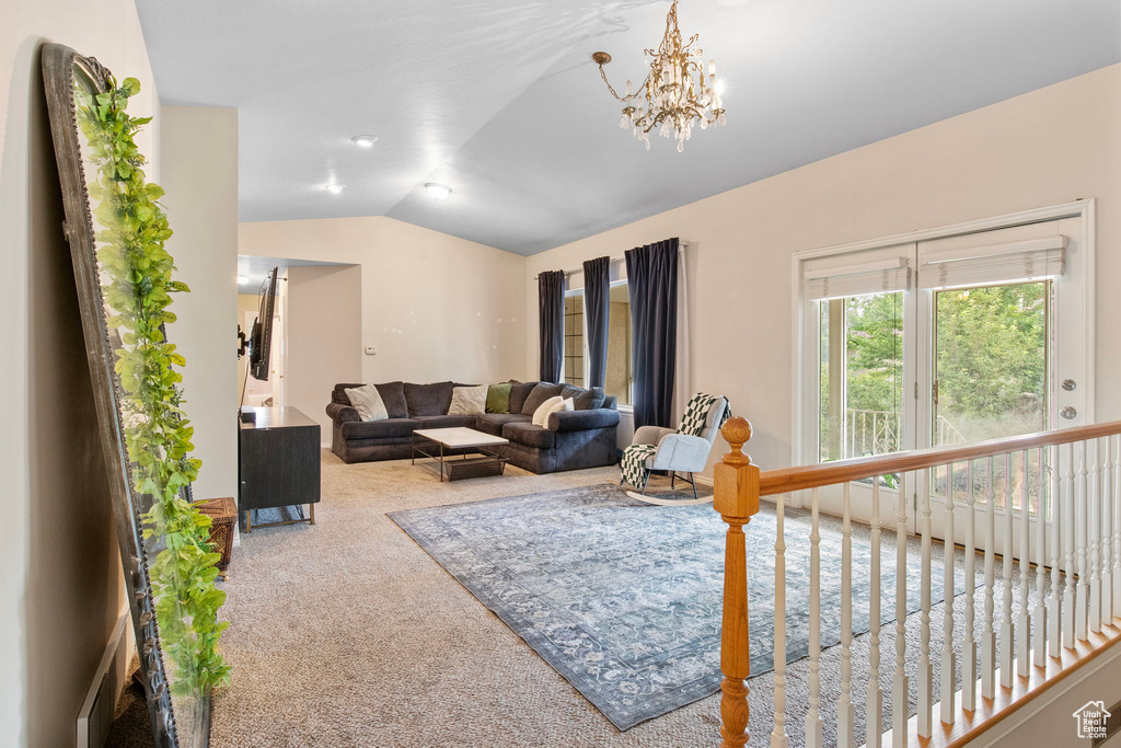 Living area with carpet, lofted ceiling, and a chandelier