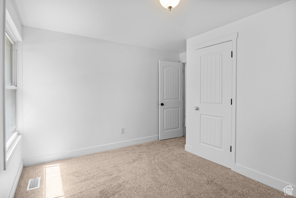 Unfurnished bedroom featuring carpet floors and baseboards
