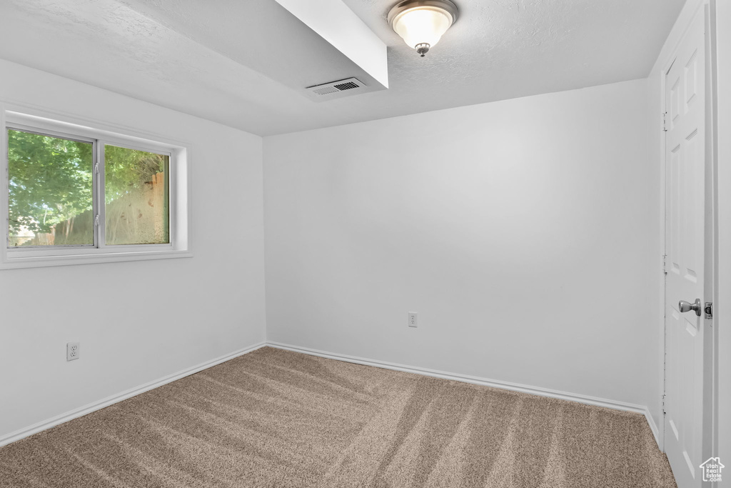 Carpeted empty room with baseboards