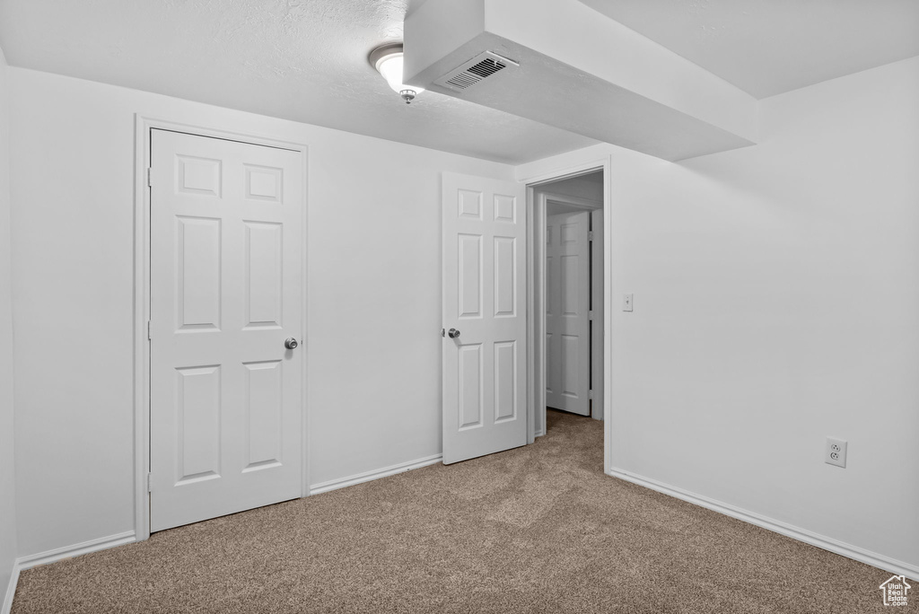 Unfurnished bedroom featuring carpet and baseboards