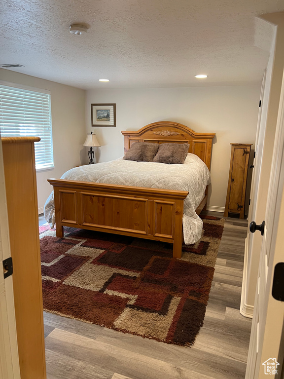 Bedroom featuring dark wood-style floors, a textured ceiling, and recessed lighting