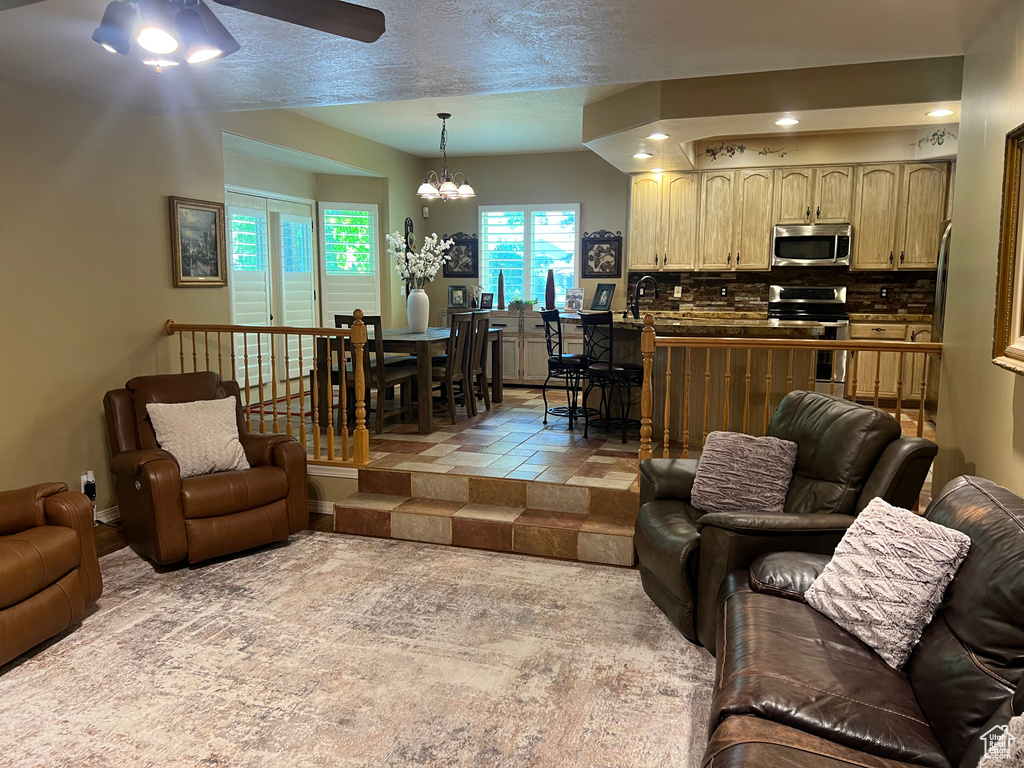 Living area with a ceiling fan, a chandelier, and recessed lighting