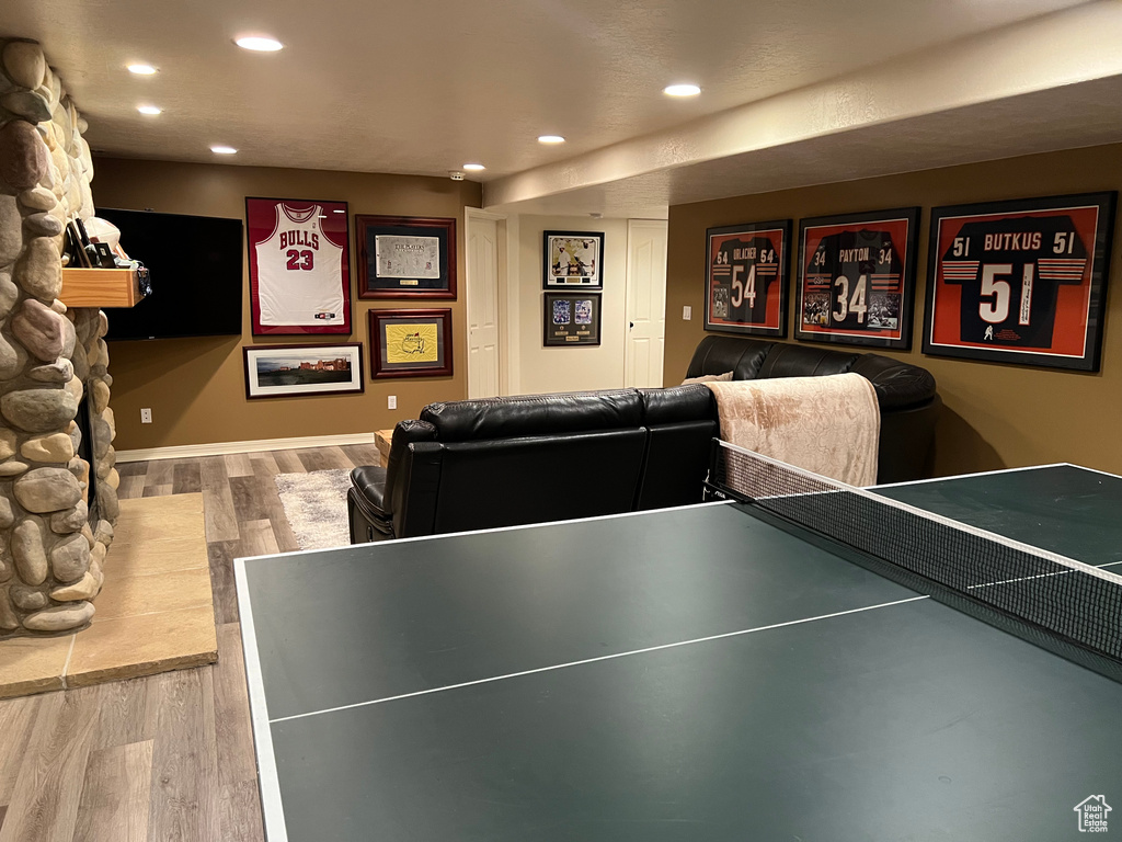 Game room with recessed lighting, wood finished floors, and a fireplace