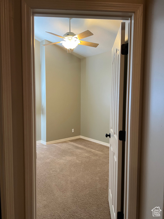 Carpeted empty room with baseboards and a ceiling fan