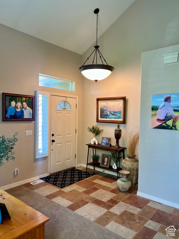 Entrance foyer featuring high vaulted ceiling and baseboards