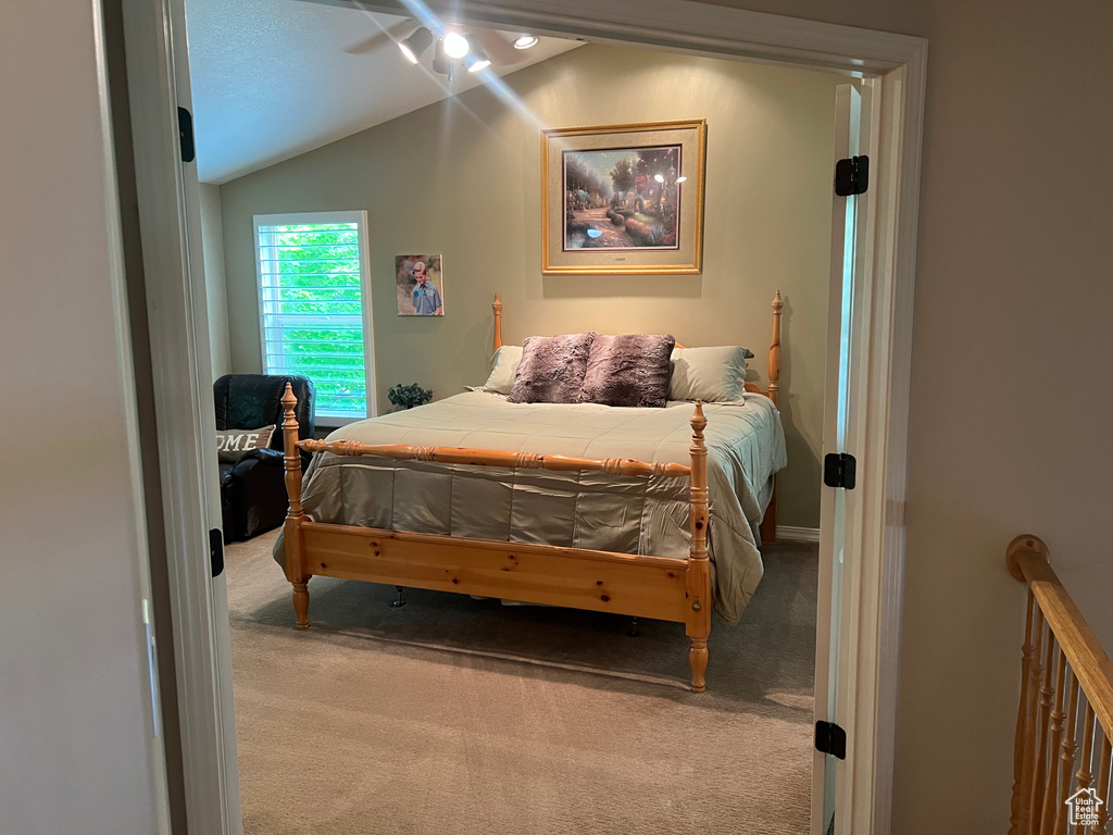 Carpeted bedroom with lofted ceiling