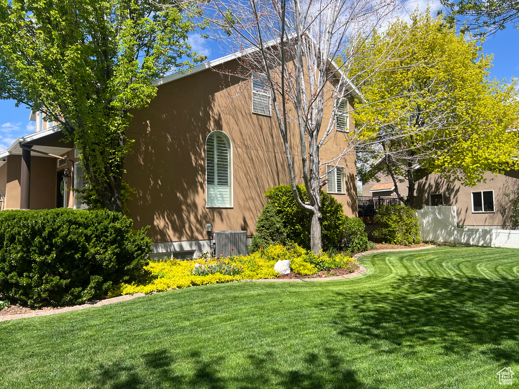 View of property exterior with central air condition unit and stucco siding