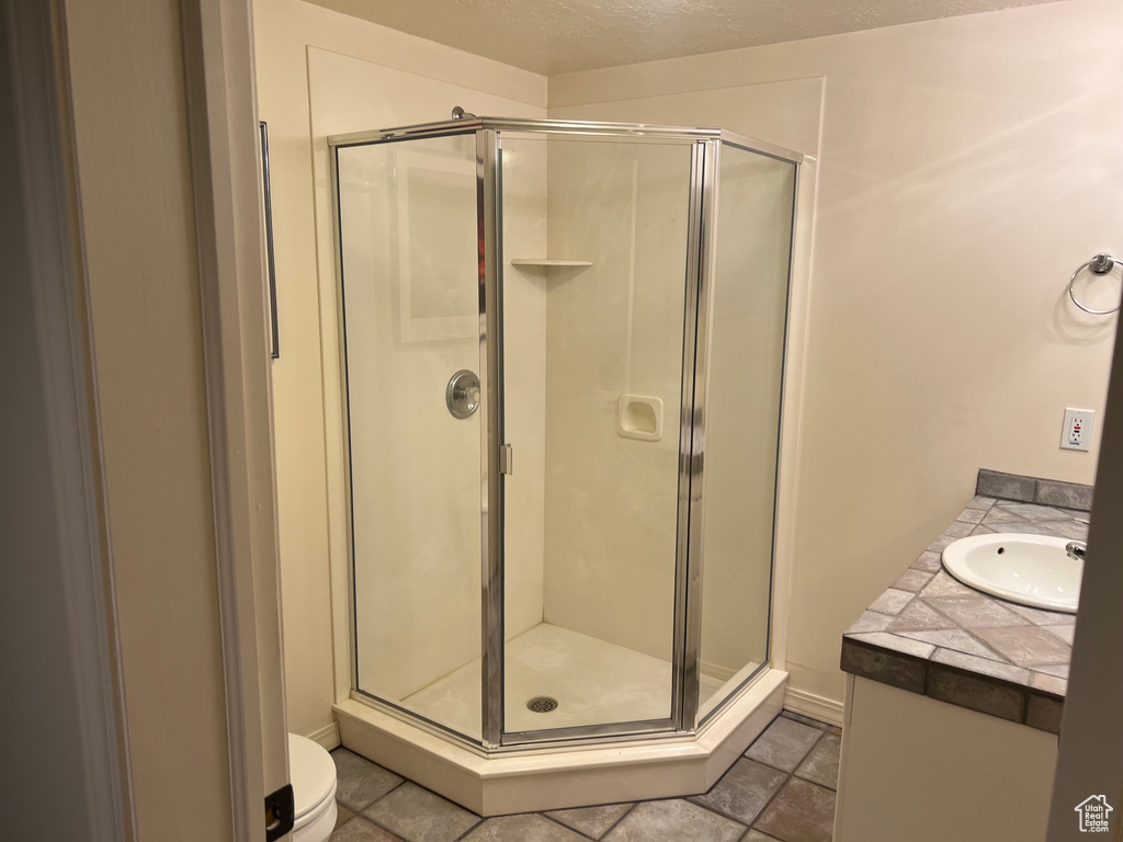 Bathroom with a shower stall, vanity, and toilet