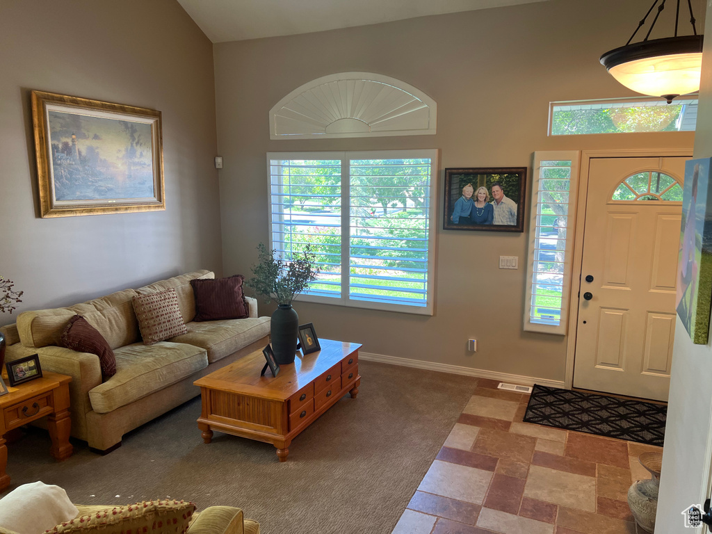 Carpeted entryway with healthy amount of natural light and baseboards