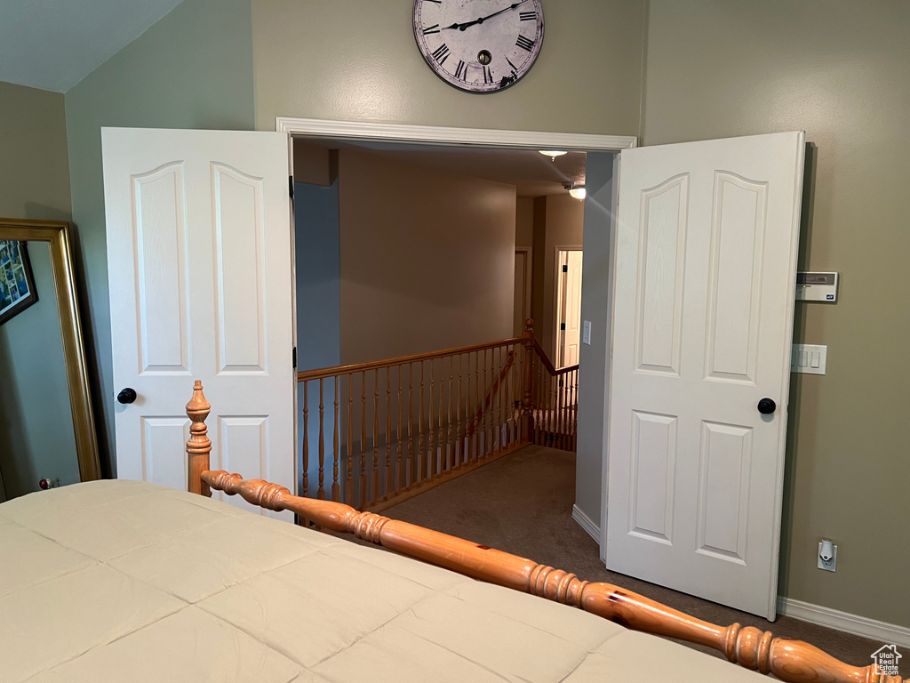 Unfurnished bedroom with carpet floors, baseboards, and lofted ceiling