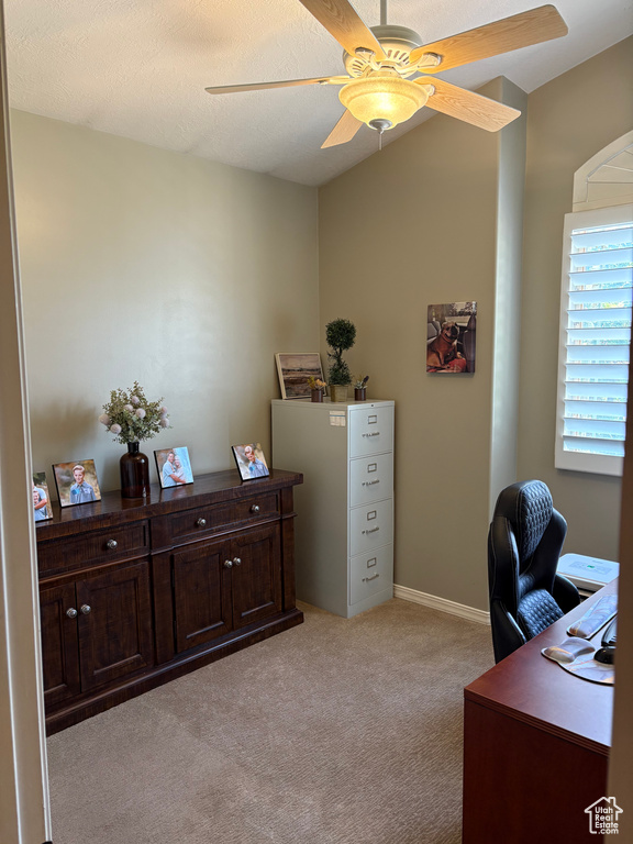 Home office featuring light colored carpet, a ceiling fan, and baseboards