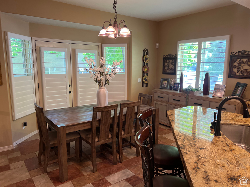 Dining room with healthy amount of natural light, a chandelier, and baseboards