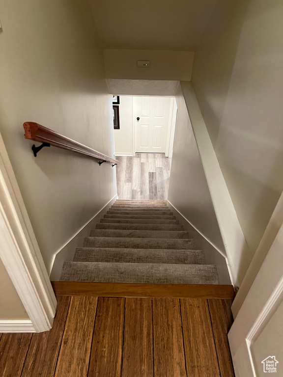 Stairs with wood finished floors and baseboards
