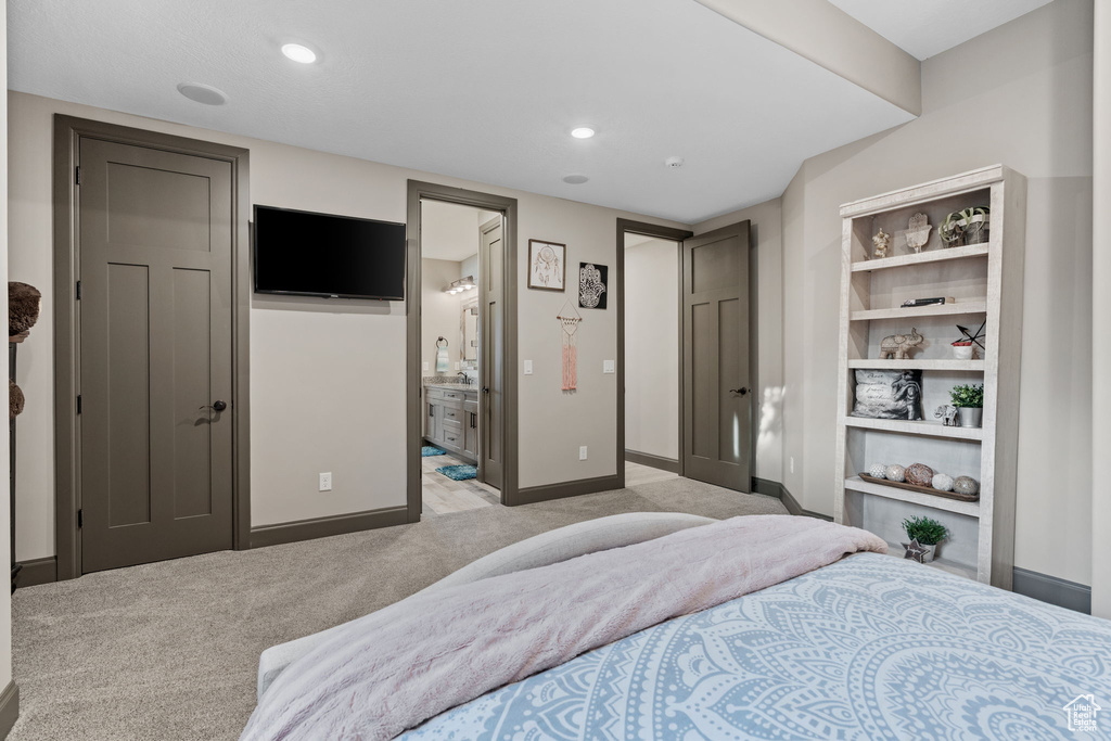 Bedroom featuring light carpet, baseboards, ensuite bath, and recessed lighting