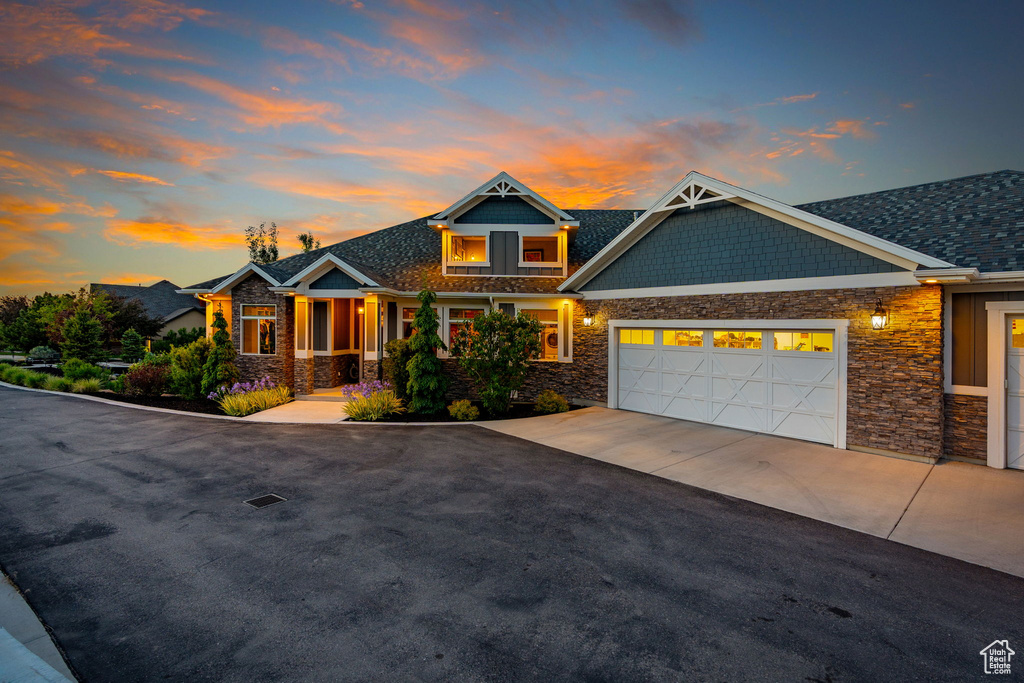 Craftsman inspired home with stone siding, driveway, a garage, and covered porch