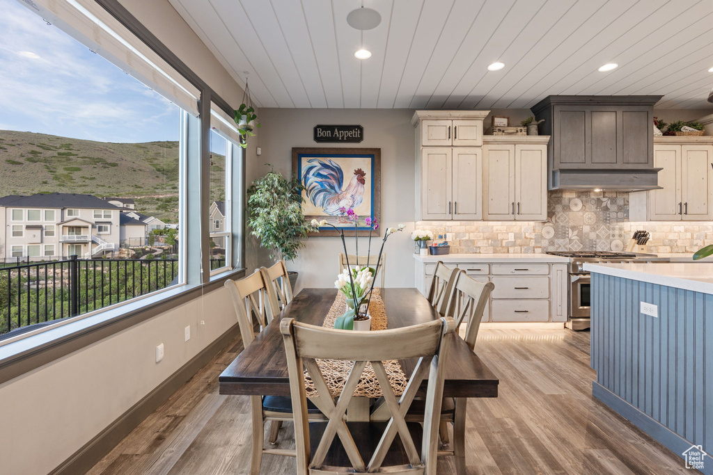 Dining room with plenty of natural light, a mountain view, light wood-type flooring, recessed lighting, and wooden ceiling