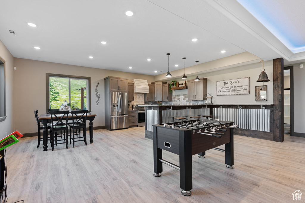 Recreation room featuring recessed lighting, light wood-type flooring, and baseboards
