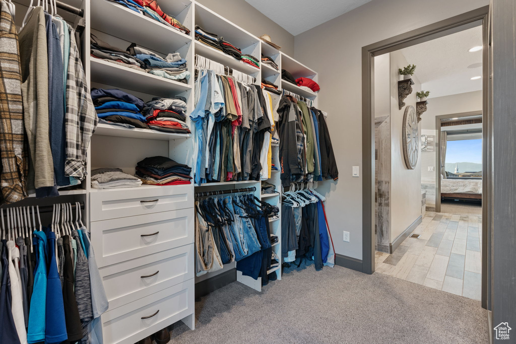 Walk in closet with light colored carpet