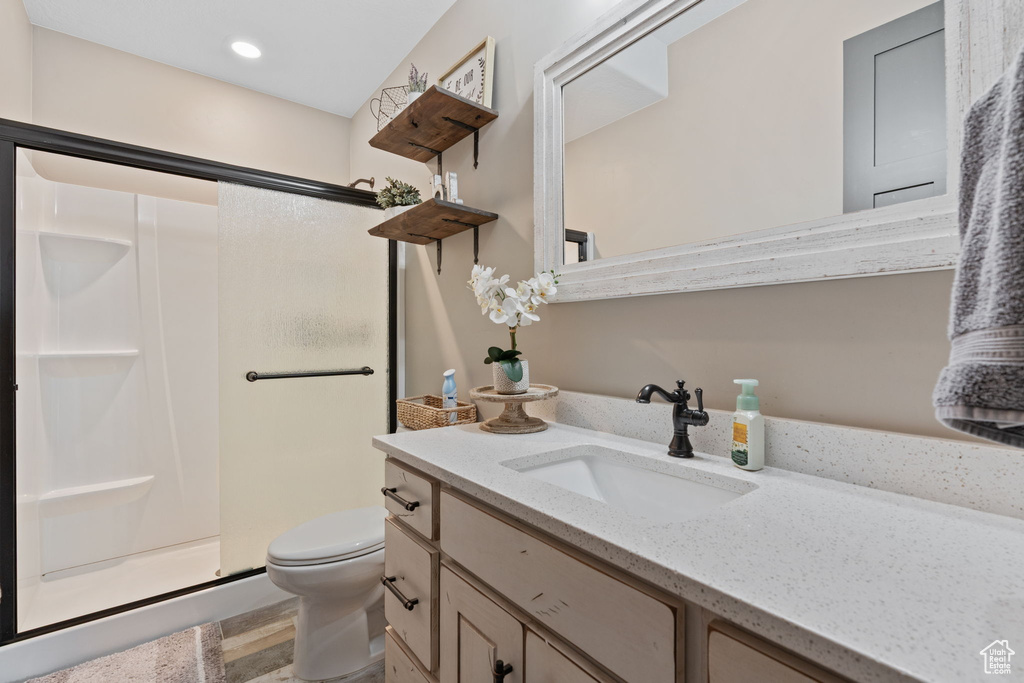 Full bathroom featuring a stall shower, vanity, toilet, and recessed lighting