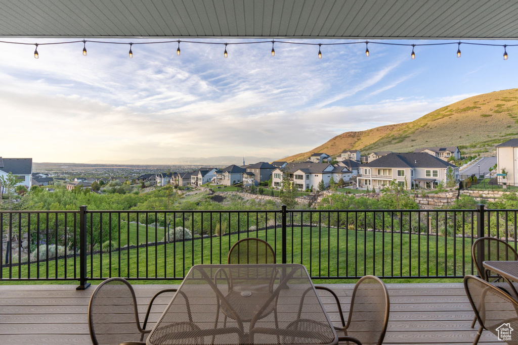 Wooden terrace featuring a residential view, a mountain view, and a yard