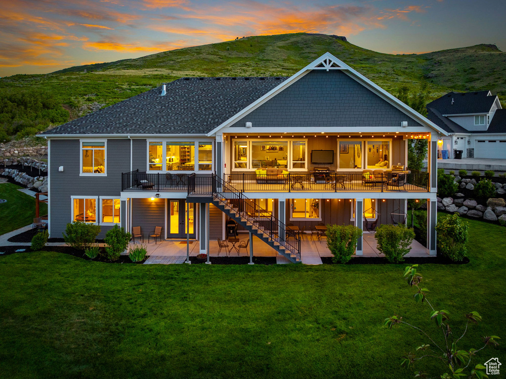 Rear view of house with a patio, a deck, stairway, and a lawn