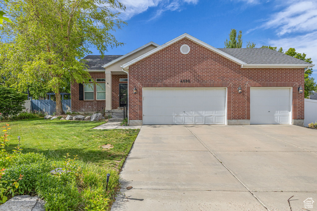 View of front of house featuring an attached garage, concrete driveway, brick siding, and a shingled roof