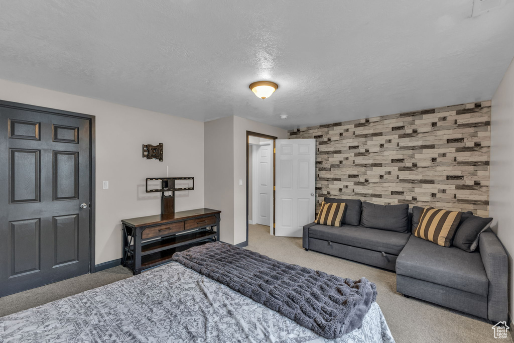 Bedroom with carpet, baseboards, and a textured ceiling