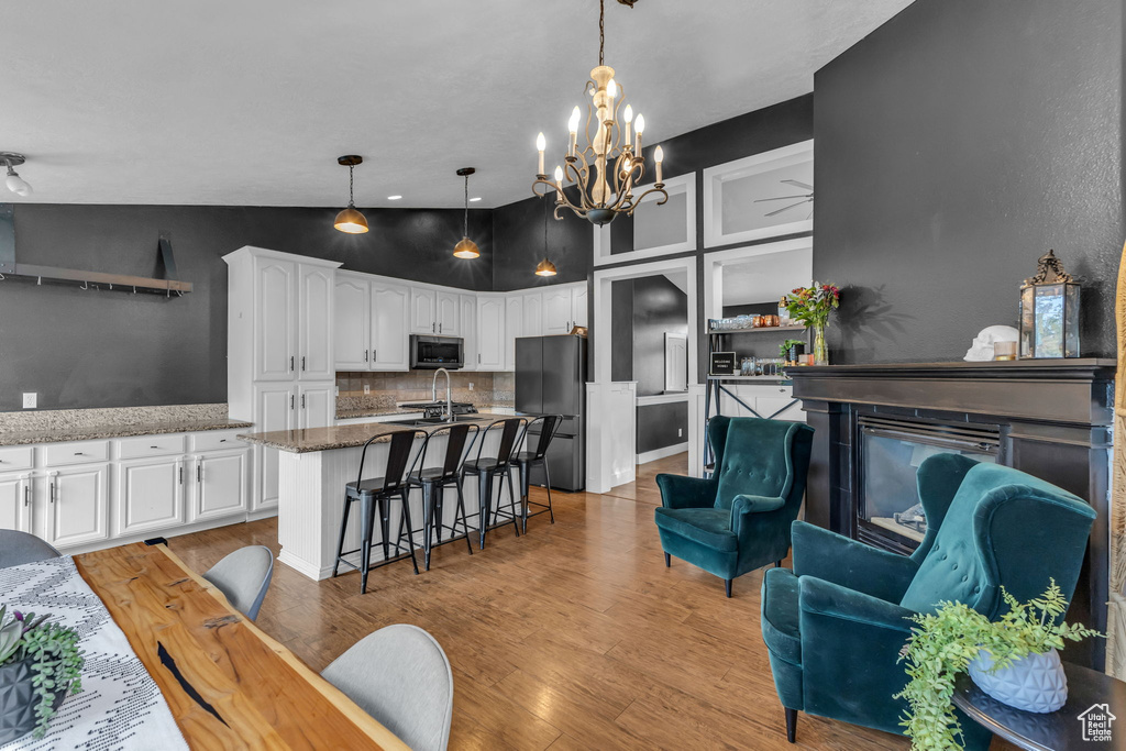 Living area featuring a chandelier, light wood-type flooring, and a fireplace