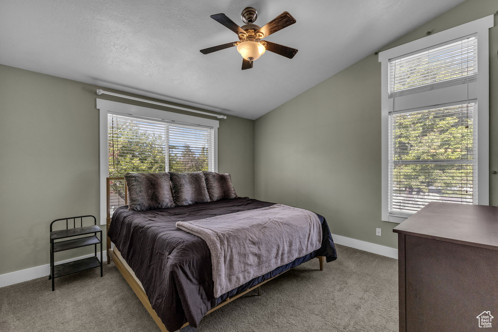 Bedroom featuring vaulted ceiling, light colored carpet, baseboards, and ceiling fan